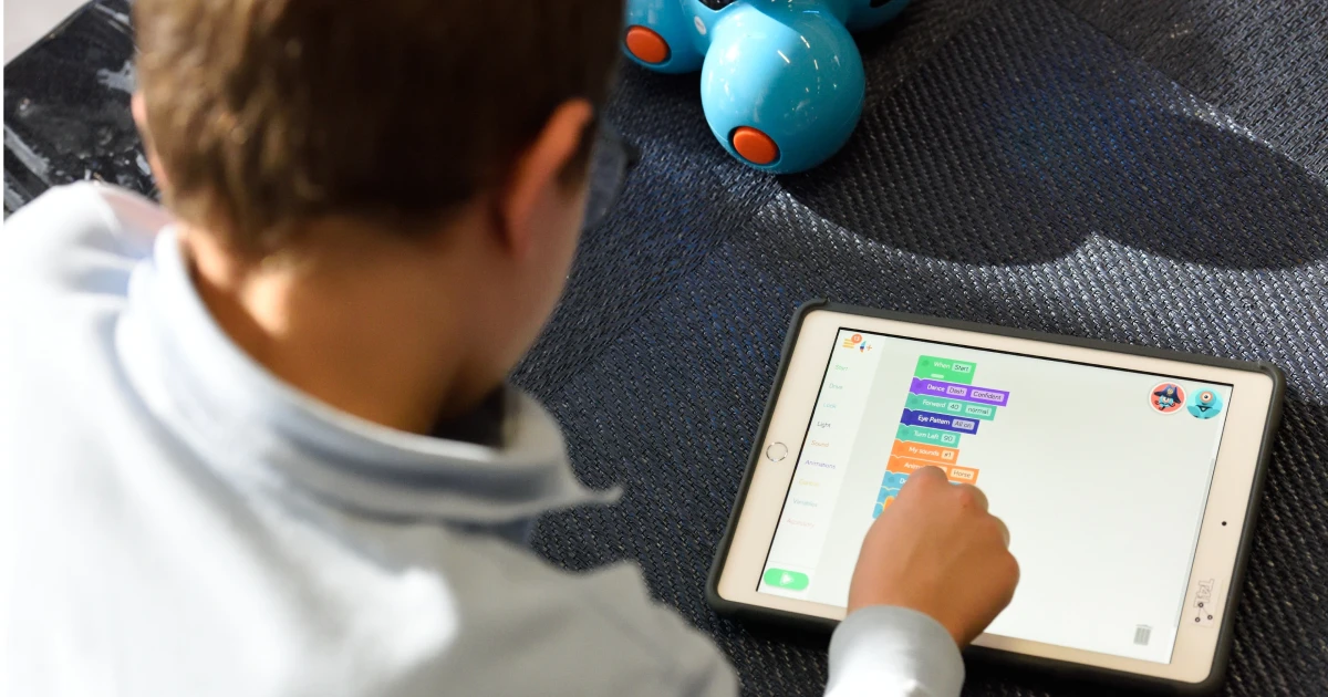 Young student working on colorful lesson on tablet device.