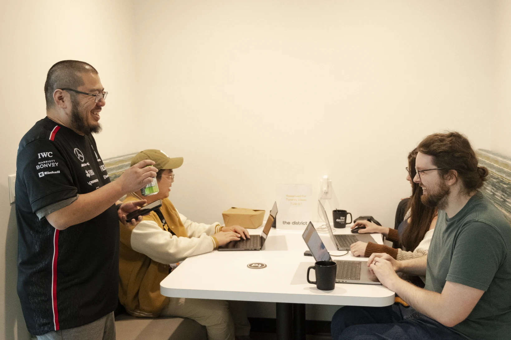 Colleagues talking together around laptops