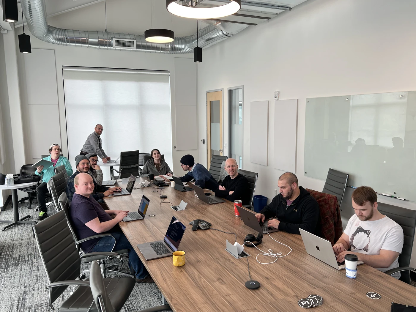 Colleagues gathered around a table with laptops and notebooks